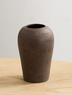 a brown vase sitting on top of a wooden table