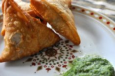 two pastries on a plate with pesto sauce