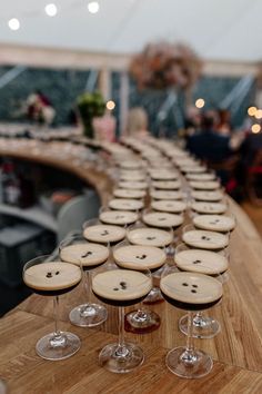 several wine glasses are lined up on a table with wooden buttons in the shape of hearts