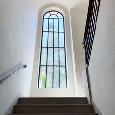 the stairs lead up to an arched window