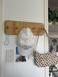 a hat and purse are hanging on the wall