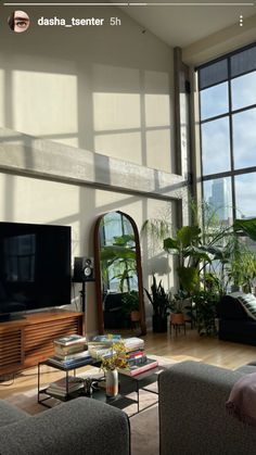 a living room filled with furniture and large windows