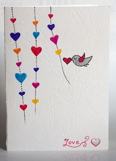 a white card with hearts and a bird on the string that says love's