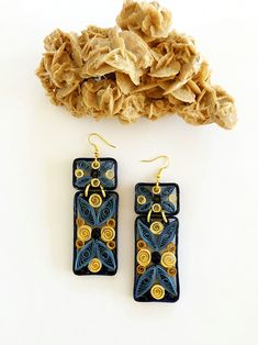 a pair of earrings sitting on top of a table next to a pile of fabric