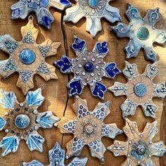 several snowflakes are arranged on a wooden surface with blue and white designs