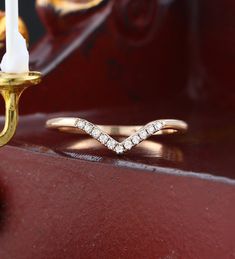 a diamond ring sitting on top of a wooden table next to a candle and other items