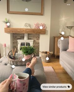 a person sitting on a couch with their feet up and holding a cup in front of them