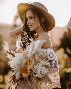 a woman wearing a hat and holding a bouquet