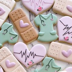 some cookies that are decorated with icing on top of a white table and one has a stethoscope