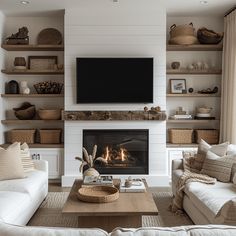 a living room filled with furniture and a flat screen tv mounted on the wall above a fire place