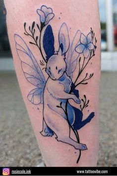 a tattoo with an image of a bunny holding a flower on it's leg