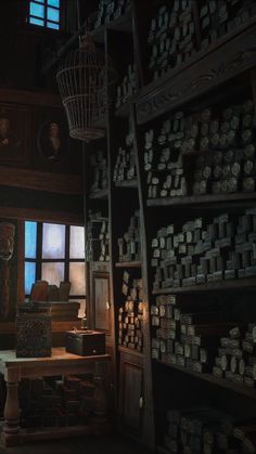 a room filled with lots of boxes and shelves next to a window in the dark