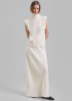 Color: Cream Midweight satiny fabric Slim fit Maxi length A-line silhouette Elasticated waist Slip on style Unlined 100% Polyester Dry Clean By The Frankie Shop. Imported Maxi Satin Skirt, Paris Store, Turtleneck Sleeveless, Denim Suit, Frankie Shop, Fitted Turtleneck, Paris Woman, Sleeveless Turtleneck, Knitted Tops