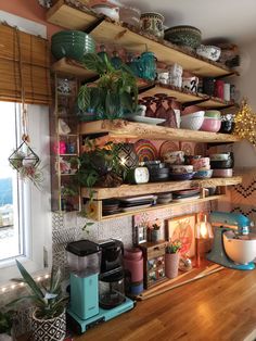 a kitchen counter with many pots and pans on top of it, along with shelves filled with dishes