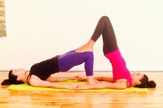 two women are doing yoga on the floor