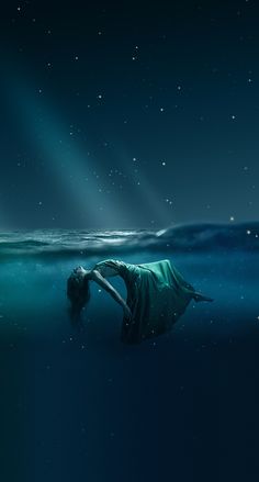 a woman floating in the ocean under water