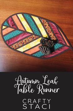 an autumn leaf table runner made with crafty staci strips and pine cones