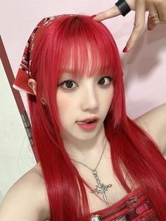 a woman with long red hair and piercings on her head is posing for the camera