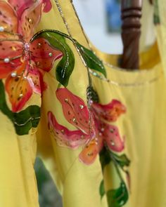 two yellow dresses with pink flowers on them