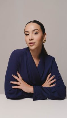 a woman sitting at a table with her arms crossed