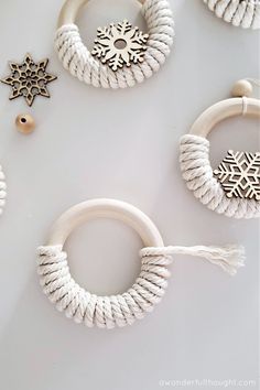 some white rope and wooden beads are hanging on the wall with snowflakes