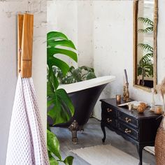 a bath tub sitting next to a black dresser