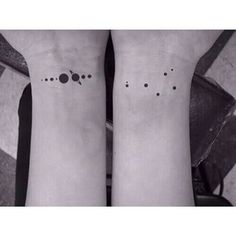 two people with matching tattoos on their legs, both have small dots and are facing each other