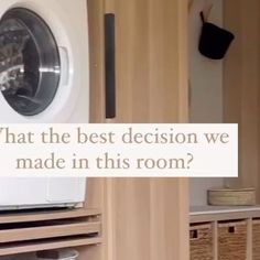 a washing machine sitting inside of a dryer next to a wooden shelf with baskets on it