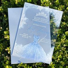 two wedding cards with snowflakes on them sitting in the grass next to some bushes