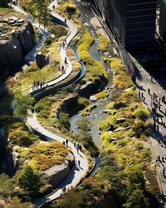 an aerial view of people walking and riding bikes on a curved path next to a river