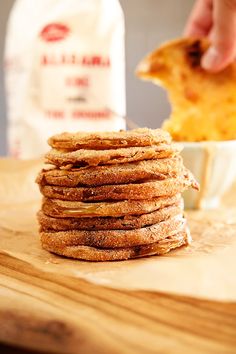 a stack of pancakes sitting on top of a wooden table next to a bag of chips