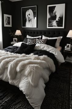 a black and white bedroom with two pictures on the wall above the bed that is covered in fur