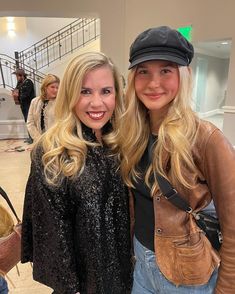 two beautiful young women standing next to each other in front of a staircase and stairs