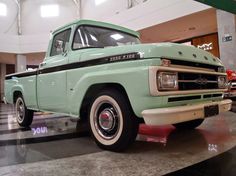 an old green pick up truck is on display