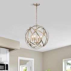 a kitchen with a table, chairs and a light fixture hanging from the ceiling above it