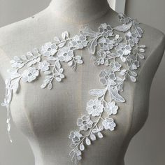 a mannequin with white lace and flowers on it