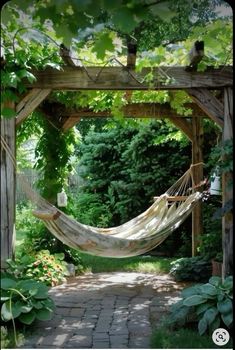 a hammock hanging from a wooden structure in the middle of a garden area