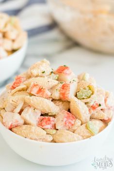 a white bowl filled with pasta salad on top of a table