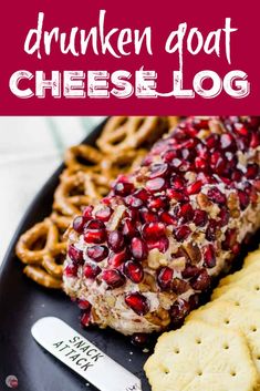 a plate with crackers, cheese and pomegranates on it next to some pretzels