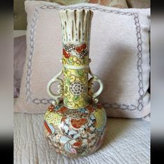 a decorative vase sitting on top of a bed