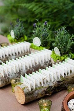 a table topped with lots of wooden slices covered in small white squares next to cups