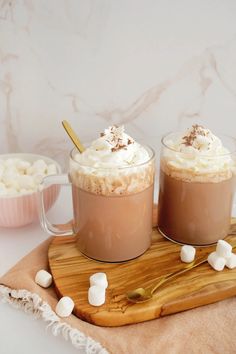 two glasses filled with hot chocolate and marshmallows