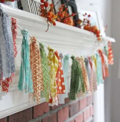 colorful ribbons are hanging on the mantle in front of a brick wall and fire place