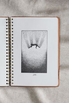 an open notebook with black and white drawings on it