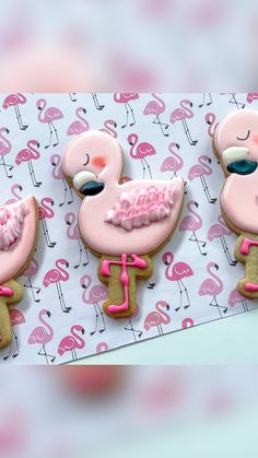 three decorated cookies in the shape of flamingos