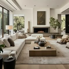 a modern living room with white couches and large windows in the back ground area