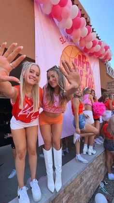 two girls in cheerleader outfits posing for the camera