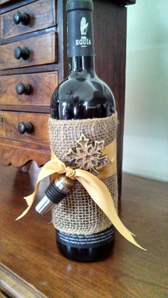 a wine bottle wrapped in burlap with a bow