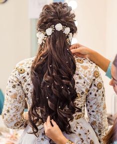 a woman is getting her hair done by another person