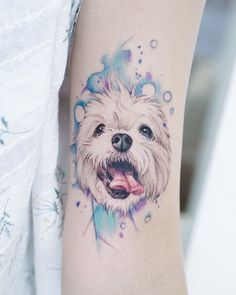 a watercolor style dog tattoo on the arm